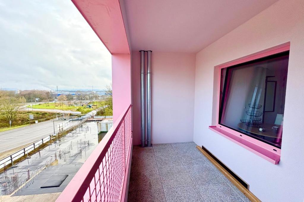 Un balcón con una gran ventana y un televisor grande. en Bright studio with a view of the Black Forest, en Estrasburgo