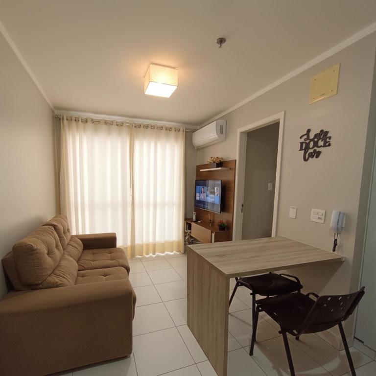 un soggiorno con un divano e un tavolo di Metropolitan Barcelona próximo ao Flamboyant e Autódromo Ar condicionado no quarto e na sala Piscina e jacuzzi no terraço academia completa restaurantes no térreo vaga privativa a Goiânia