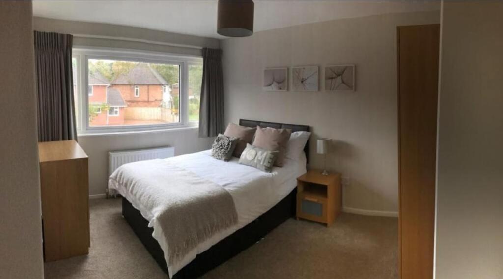 a bedroom with a large bed and a window at Cosy 4 Bed House In Solihull Near Town-NEC-BHX in Sheldon