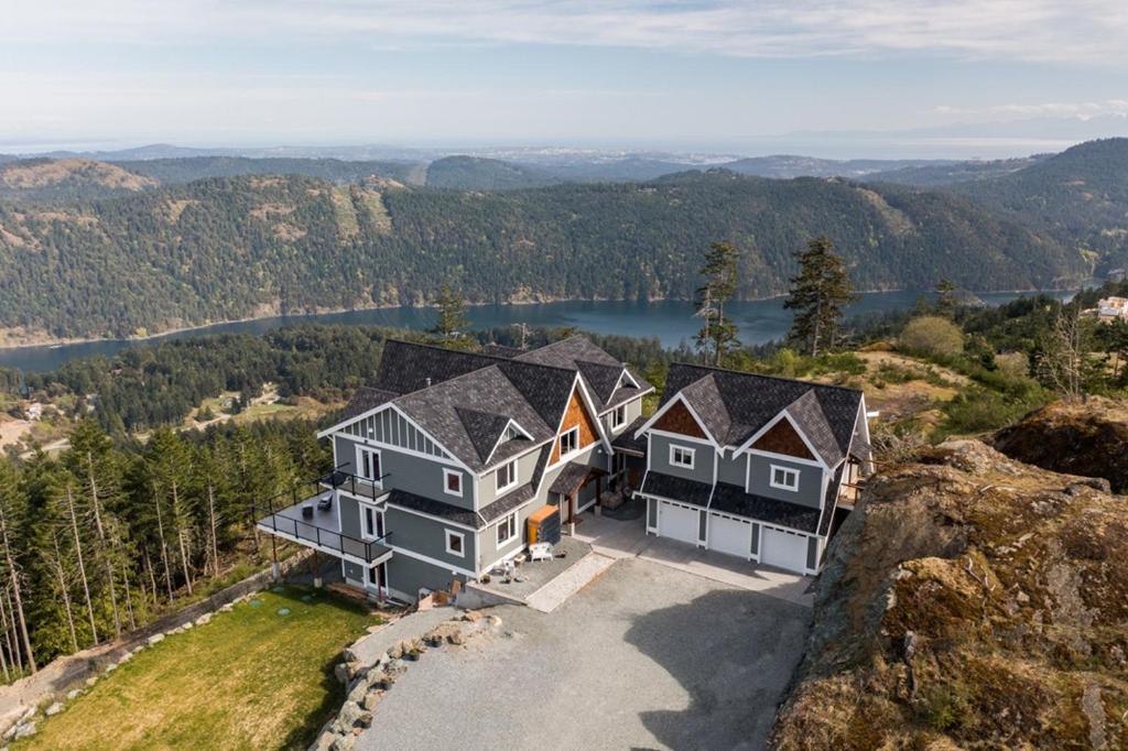 Blue Horizon Mountain Retreat B&B في Shawnigan Lake: اطلالة جوية على منزل فوق جبل