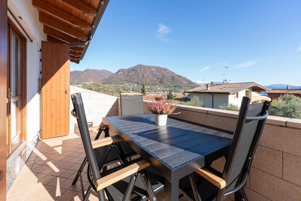 a blue table and chairs on a balcony at Green Hill apartment in Salò