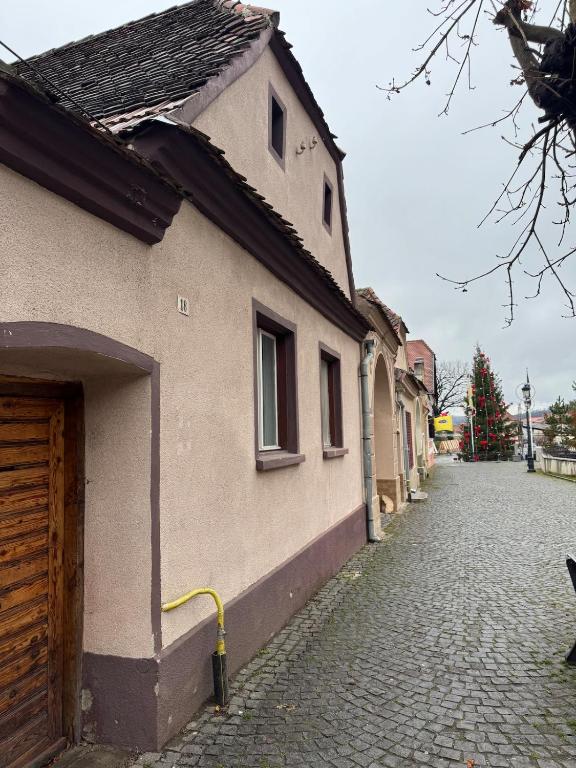 an empty street next to a building with a christmas tree at House in the Heart of Râșnov Old Town in Râşnov
