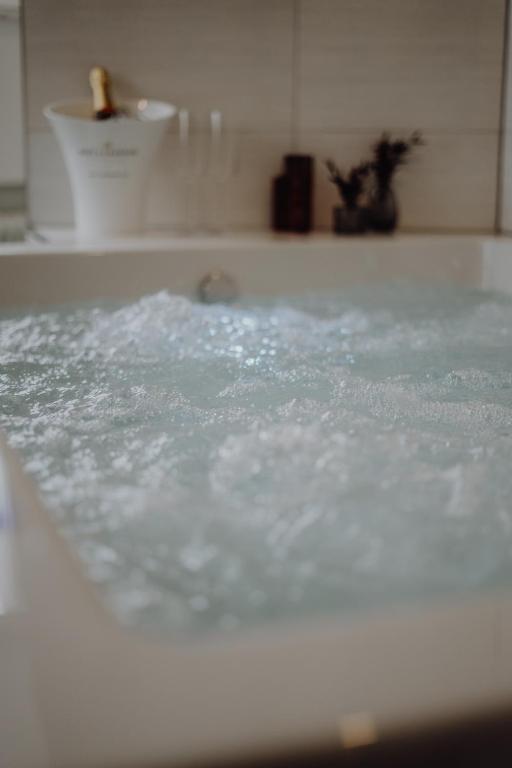 a bath tub filled with water in a bathroom at Luxus-Apartment Champagner & Spa in Herford