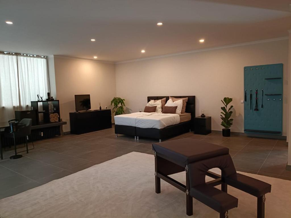 ein Schlafzimmer mit einem Bett und einem Hocker darin in der Unterkunft Luxus-Apartment Champagner&Strafbock in Herford