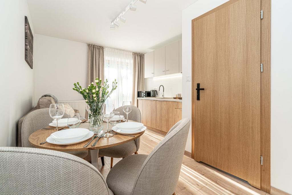 a dining room with a table and chairs and a kitchen at Ski Mountain Apartamenty - Plac zabaw - Dmuchaniec - Plac zabaw - Wypożyczalnia rowerów elektrycznych E-Bike Białka in Białka Tatrzańska
