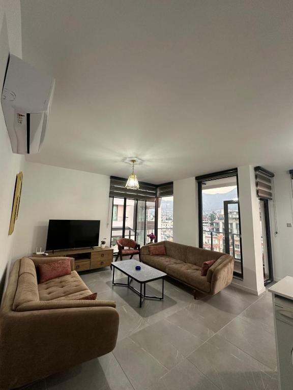 a living room with two couches and a flat screen tv at Moonlight Home in Nicosia