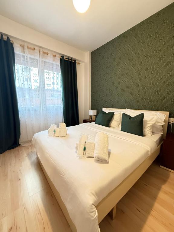 una camera da letto con un grande letto bianco con asciugamani sopra di N&N City Nest Apartment a Tirane