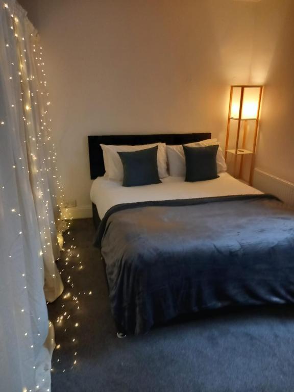 a bedroom with a bed with christmas lights at Fairy Cove Cottage in Paignton