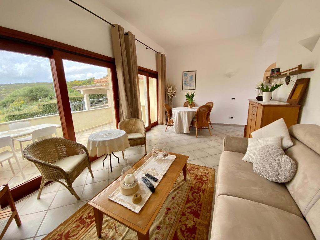 ISA - Luxury apartment Elicriso sea view with common swimming pool just 100 mt from the beach في غولفو أرانتْشي: غرفة معيشة بها أريكة وطاولة