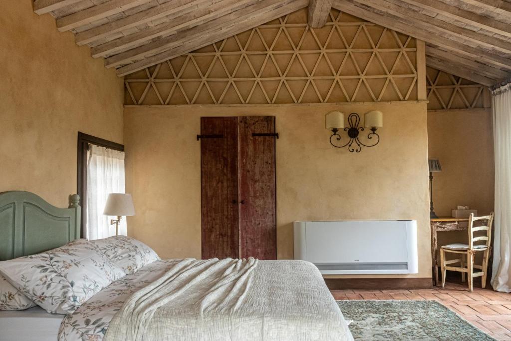 a bedroom with a bed and a table and a desk at Agriturismo La Frattina in Buonconvento