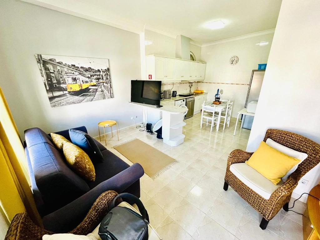 een woonkamer met een bank en stoelen en een keuken bij Casa do Omega do Foz in Foz do Arelho