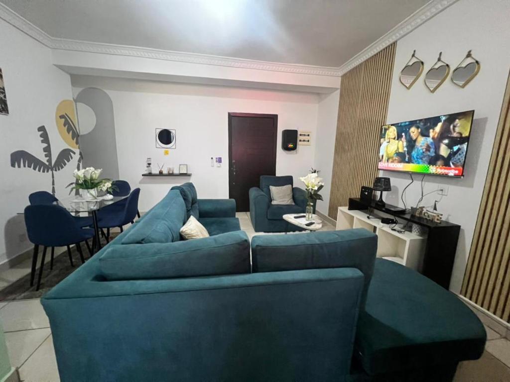 a living room with blue couches and a dining room at Wharf 303 in Pointe-Noire