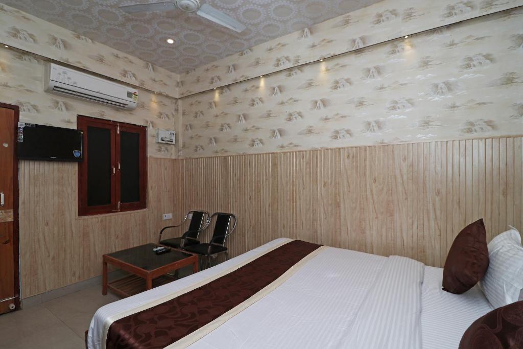 a bedroom with a bed and a desk and a chair at Hotel O Casa Nova in Transport Nagar