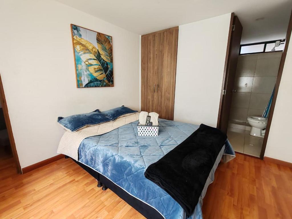 a bedroom with a bed with blue sheets and blue pillows at Aparta-estudio cerca UPTC, clínica de los andes in Tunja