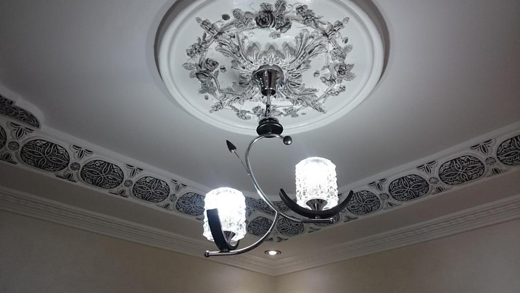 een kroonluchter in een kamer met een plafond bij Jawharat Tetouan in Souani