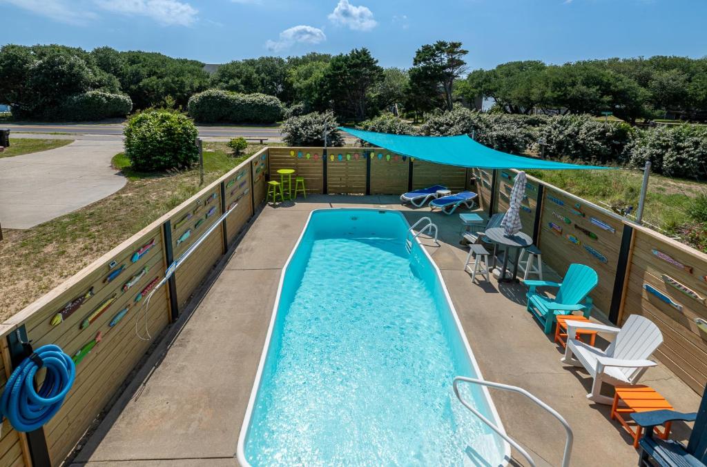 a swimming pool with a deck with chairs and a swimming poolvisor at D3943 The Pup Deck - Oceanside, Pool, Hot Tub, Pets OK, Beach & Sound Access! in North Point