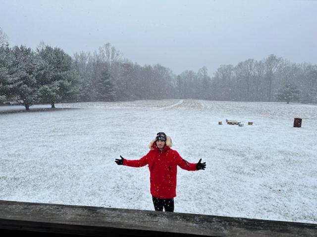 a woman standing on a fence in the snow at 15 miles to Windham Mountain ! King Bed, Game Room, Out Door Patio in Cairo