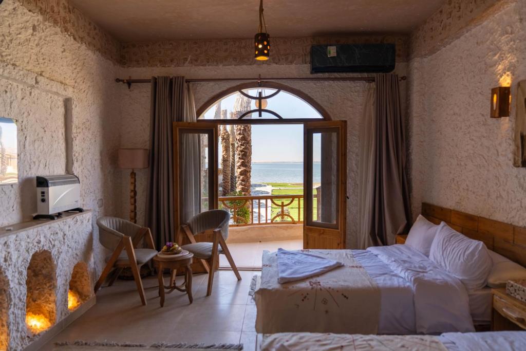 ein Schlafzimmer mit Bett und Blick auf das Meer in der Unterkunft Breezy island Hotel in Siwa