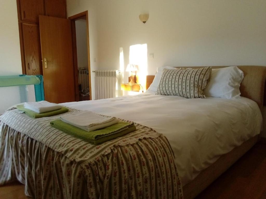 a bedroom with a bed with two towels on it at Casa das Oliveiras - Manteigas in Manteigas