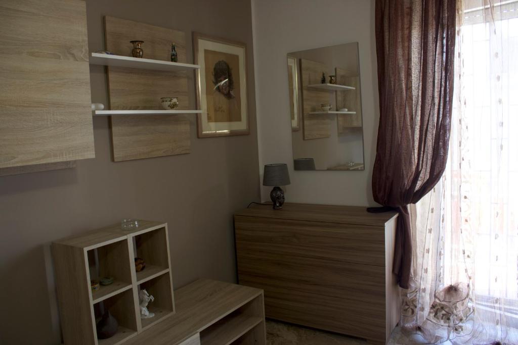 un soggiorno con cassettiera e finestra di Emilia Tre appartamento con due camere a Piacenza