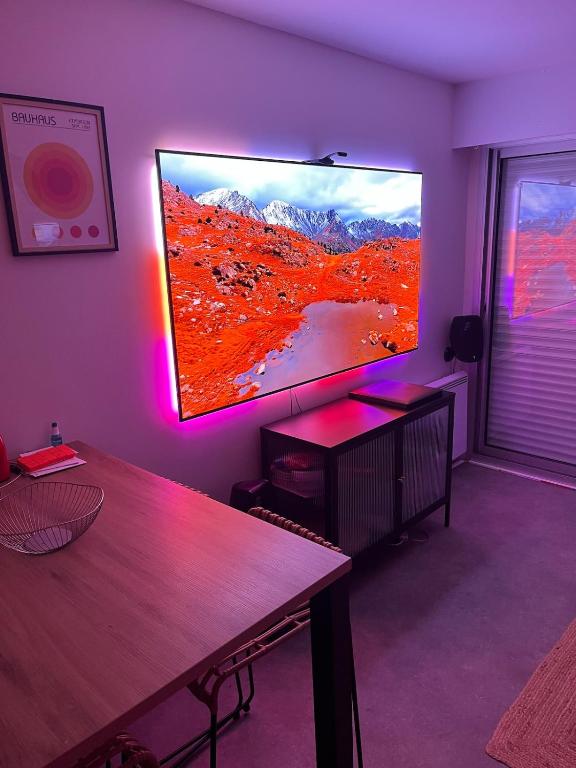 a living room with a large flat screen tv on the wall at La loge Royale in Cucq
