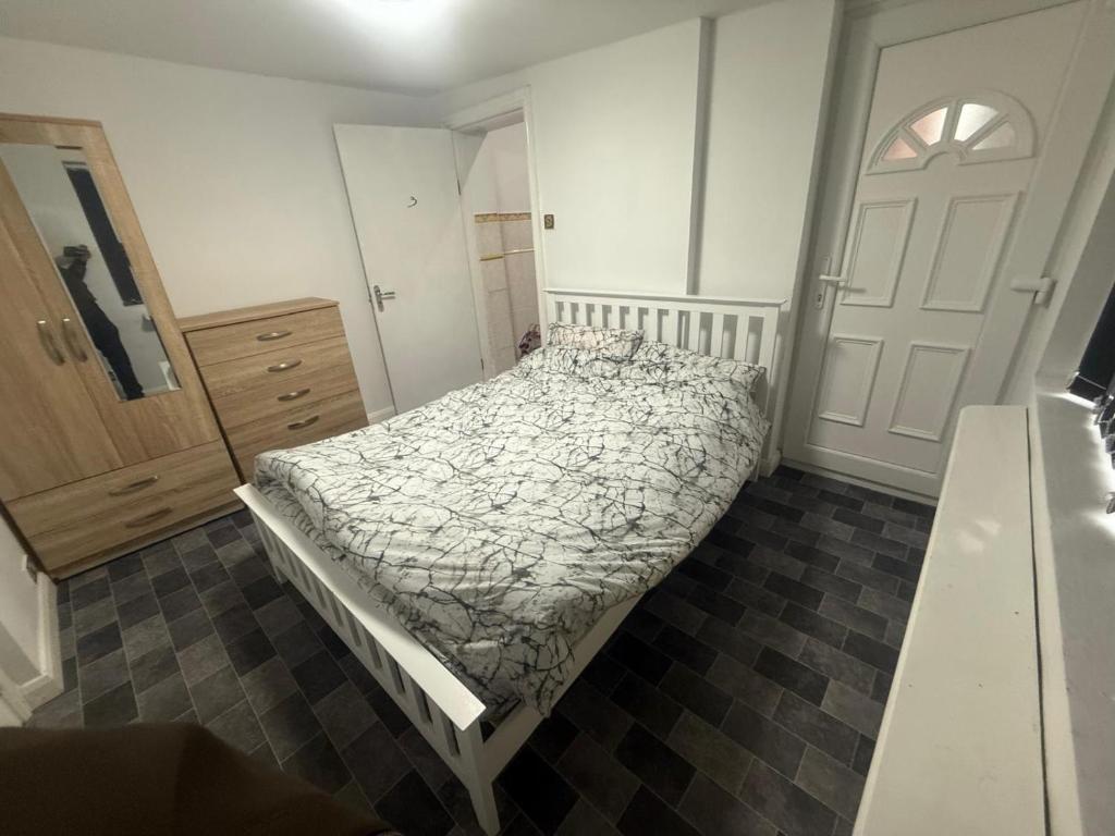 una camera con un letto, un comò e una porta di stay and relax a Manchester