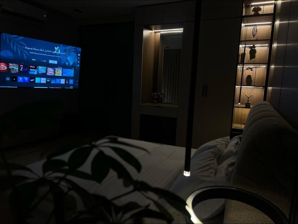 a dark room with a bed and a tv at استديو ميرا in Abha