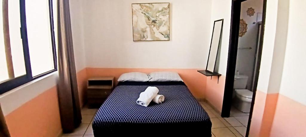 Ένα ή περισσότερα κρεβάτια σε δωμάτιο στο Maravilla en el Centro Histórico de GDL