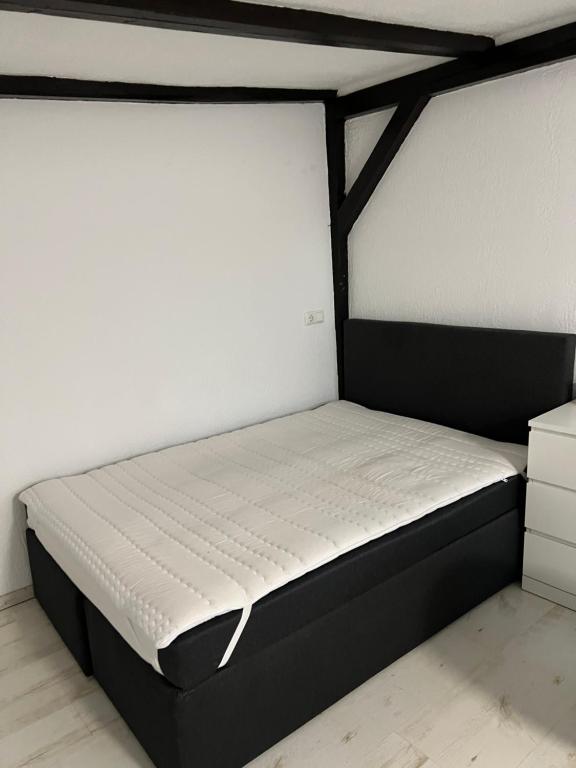 un letto con struttura nera in una stanza di 1 Zimmer Häuschen a Itzehoe