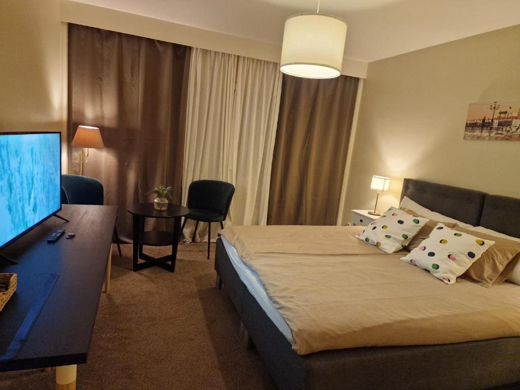 a hotel room with a bed and a flat screen tv at Noah Longstay in Västerås