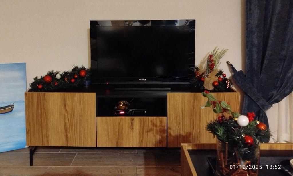 een entertainmentcentrum met een televisie en kerstversieringen bij Simple and Relaxing House! in Kalamata