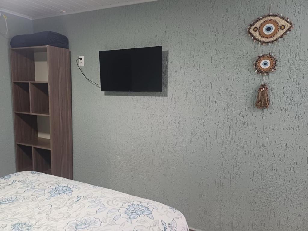 巴拉那瓜Pousada da Rê Ilha do Mel Encantadas的卧室配有壁挂式平面电视。