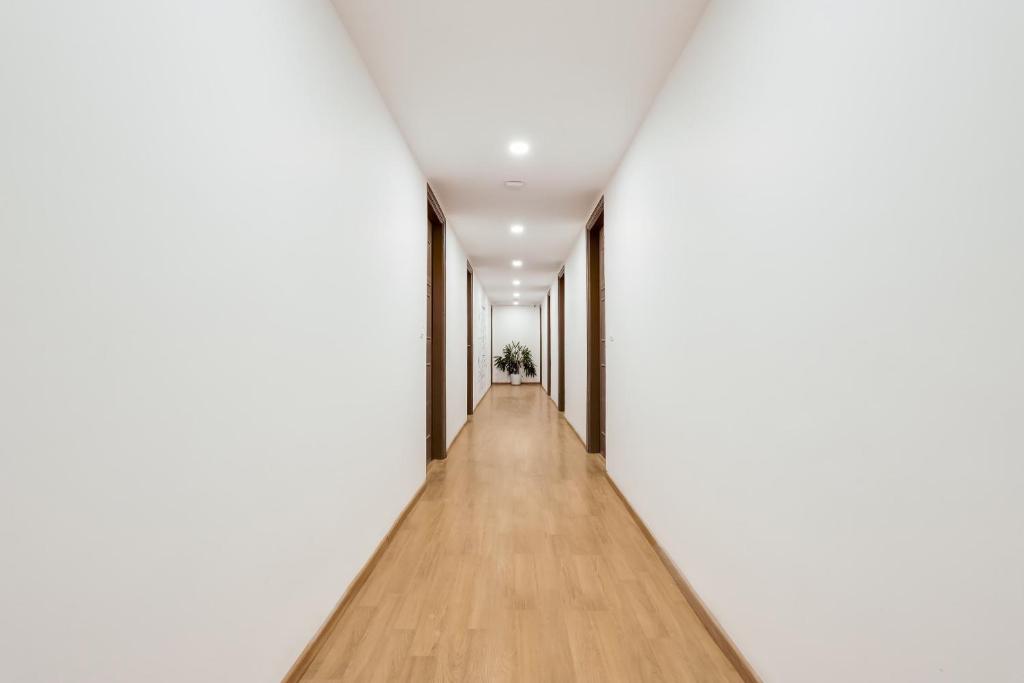 a long corridor with white walls and wooden floors at Townhouse Golden Avenue Road in Amritsar