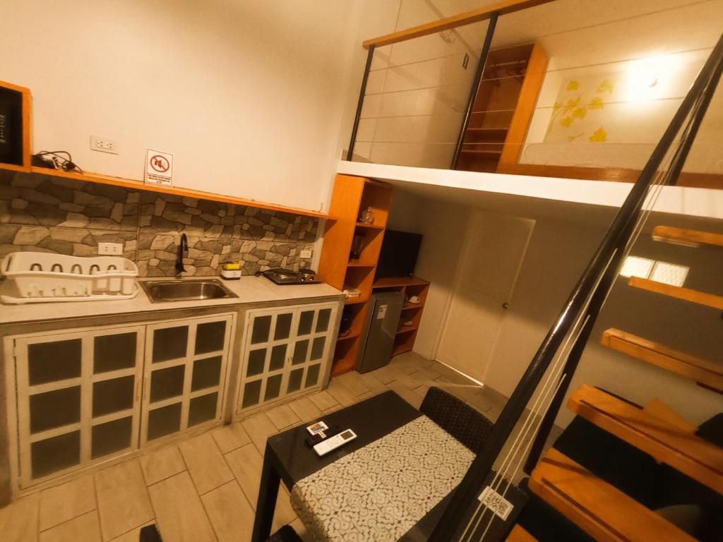 a small kitchen with a staircase leading up to a loft at Mi Quinta Raíz Loft Apartments in Iquitos