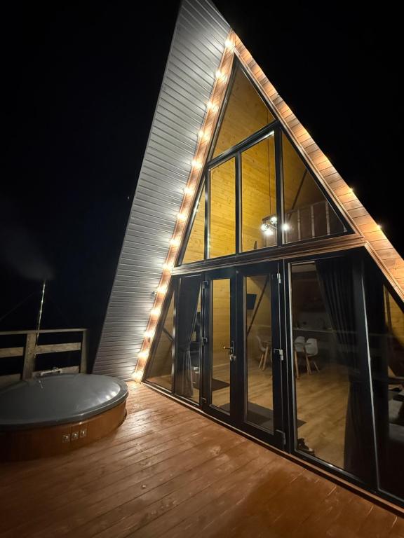 ein Haus mit einem großen Fenster und einem Holzboden in der Unterkunft Лісовий Трикутник in Mykulytschyn