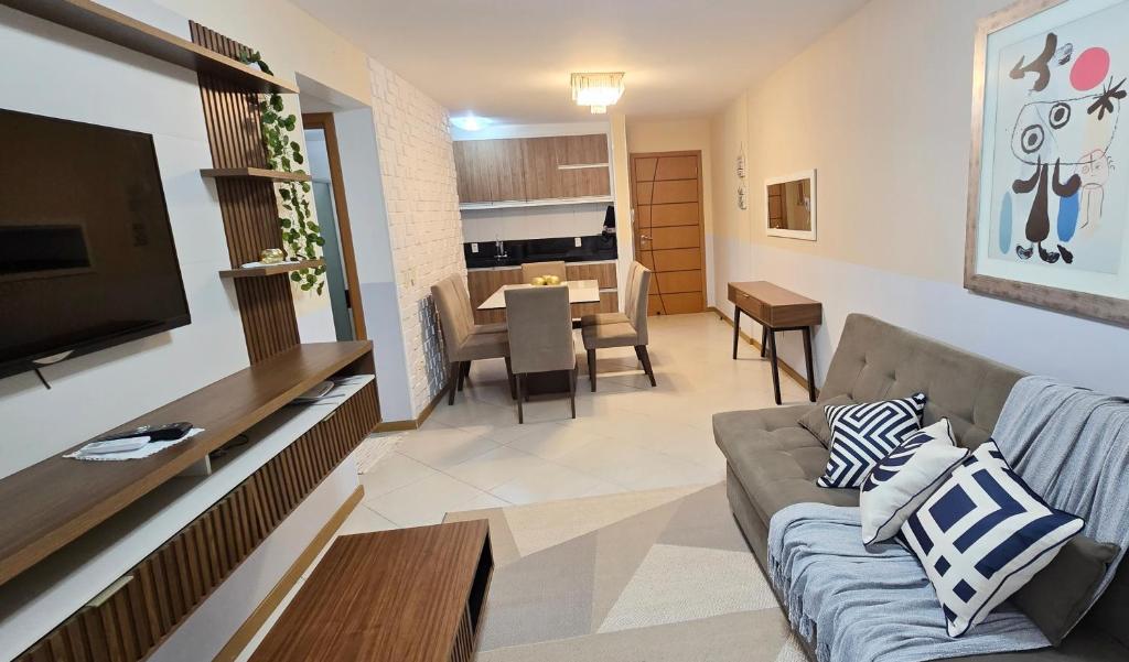 ein Wohnzimmer mit Couch und ein Esszimmer in der Unterkunft Jardim das Américas in Bombinhas