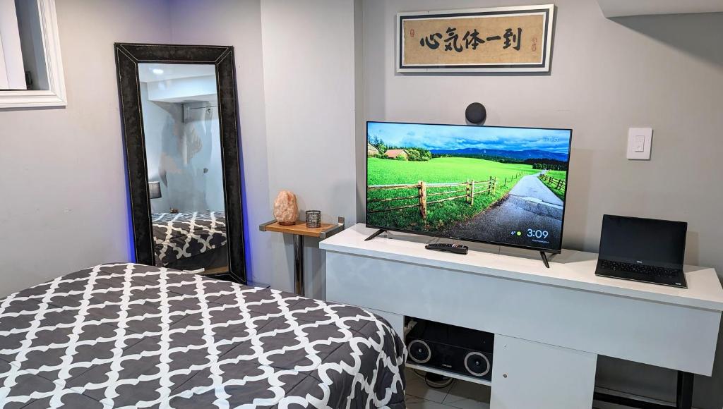 a bedroom with a bed and a television on a desk at Chic Japanese Vibe Smart Home- Liberty Village 10 min walk to CNE & GO Station in Toronto