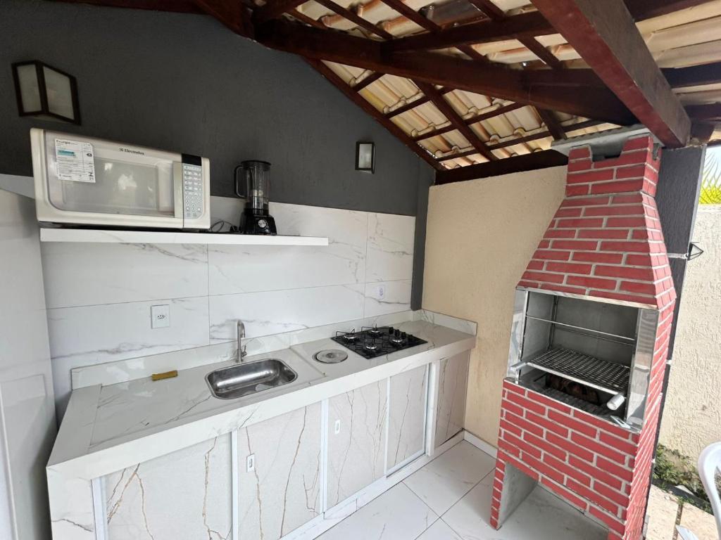 una piccola cucina con forno a microonde e fornello di Suíte península de Búzios a Búzios