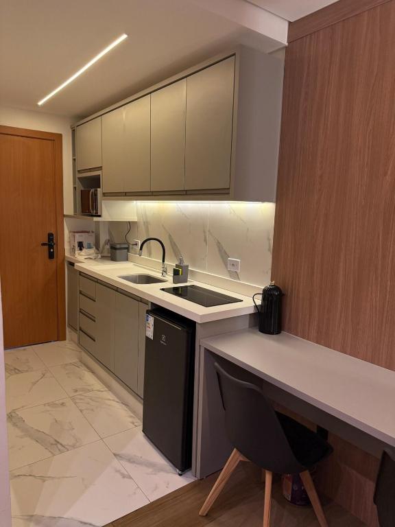 a kitchen with a sink and a counter top at Studio Novo Moderno e Aconchegante - Centro in Paranaguá