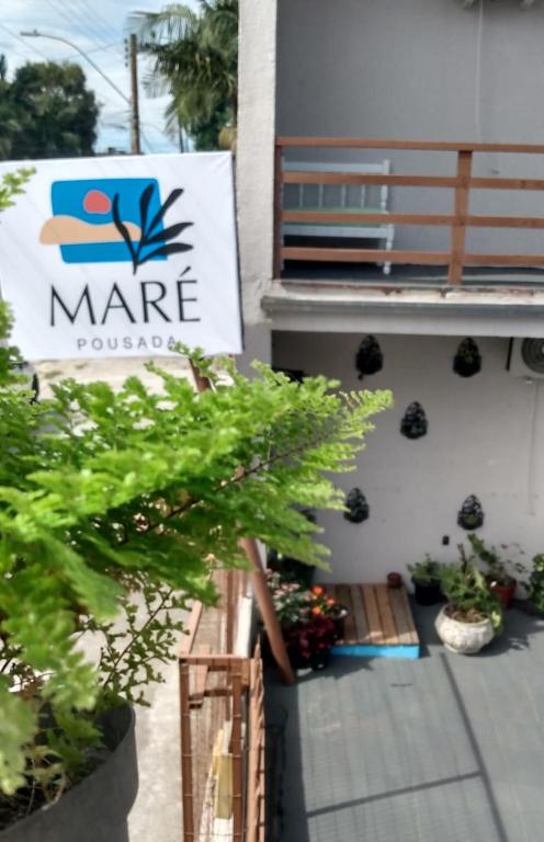 a sign for a marne house with plants on a patio at Pousada maré torres in Torres