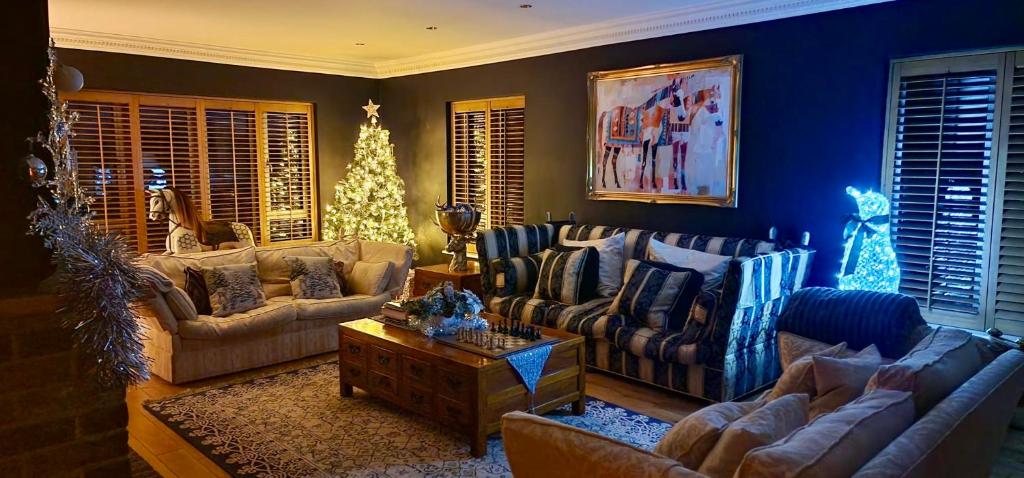 a living room with couches and a christmas tree at Stud House in Private Country Estate near Bruton in Gillingham