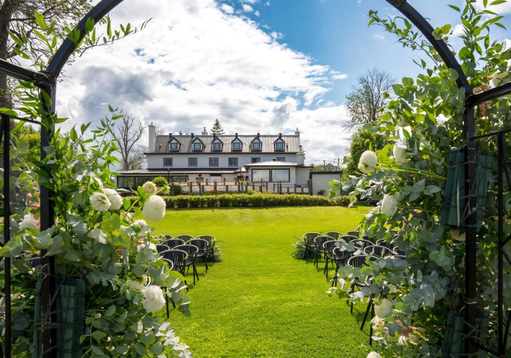 Auberge Willow Inn في Hudson: حديقة بها كراسي ومبنى في الخلفية