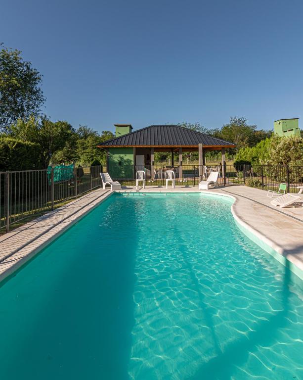 a swimming pool with chairs and a gazebo at Tierras de Breena in Los Reartes
