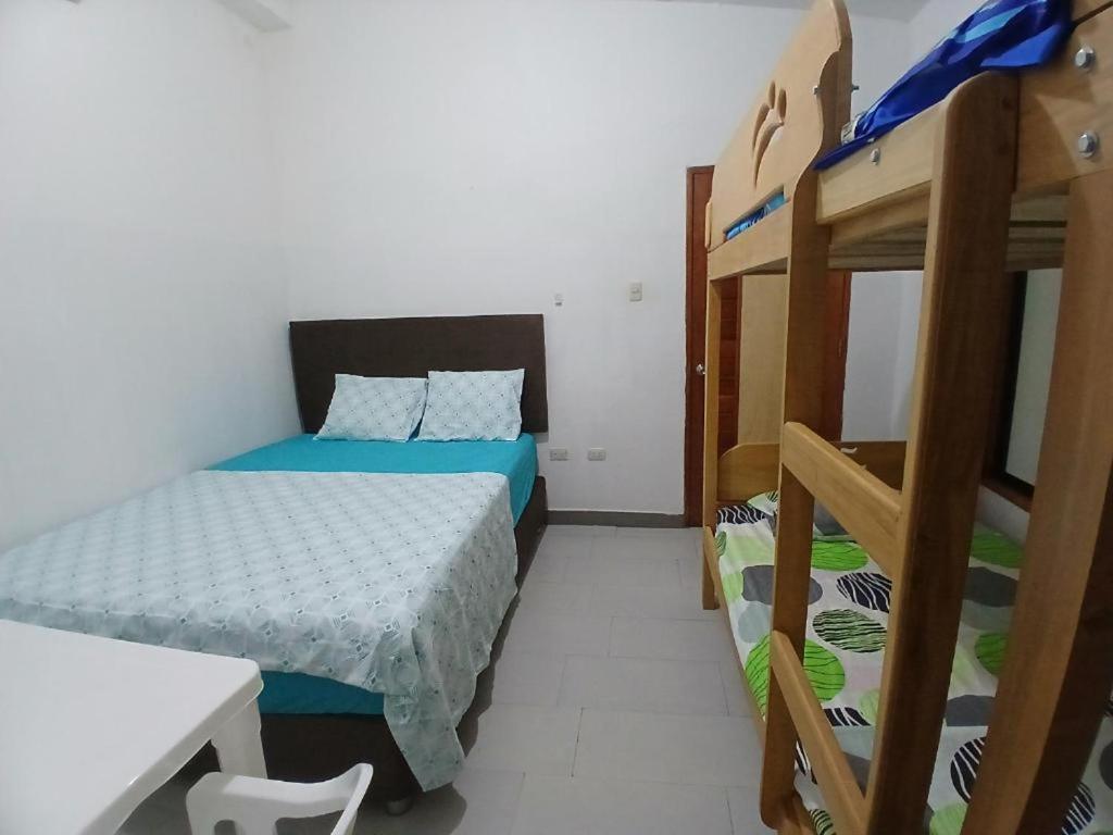 a bedroom with two bunk beds and a desk at Hotel Perezoso in Iquitos