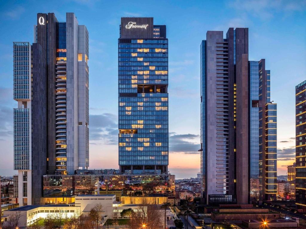 eine Gruppe großer Gebäude in einer Stadt bei Dämmerung in der Unterkunft Fairmont Quasar Istanbul Hotel in Istanbul
