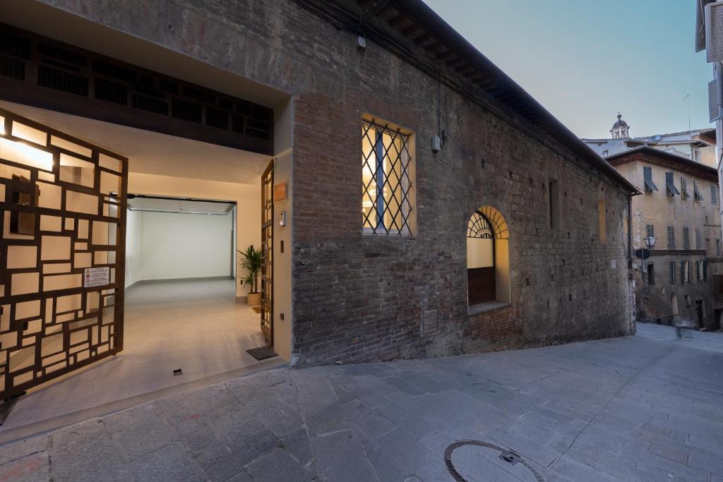 an open door of a brick building with a garage at B&B IL MORO Boutique Rooms in Siena