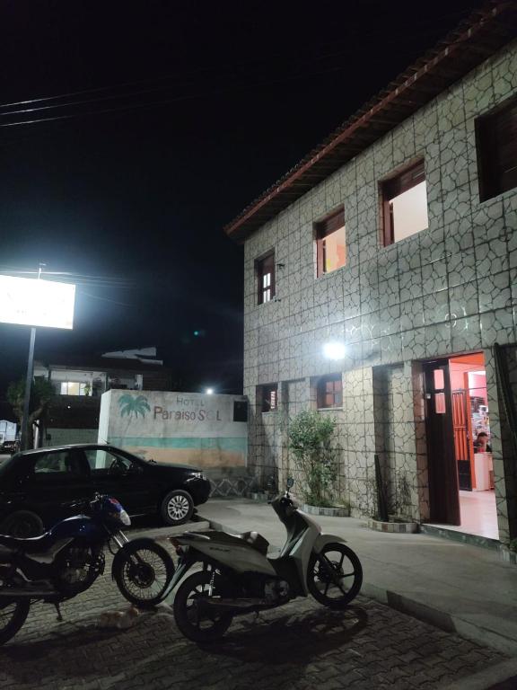 Dos motocicletas estacionadas frente a un edificio por la noche en Hotel Paraiso do Sol de Itarema, en Itarema