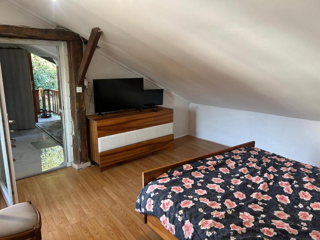 にあるCharmante Maisonのベッドと薄型テレビのある寝室