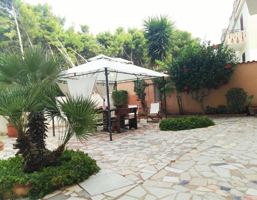 une terrasse avec un parasol, une table et des chaises dans l'établissement Villalba, à Castellammare del Golfo