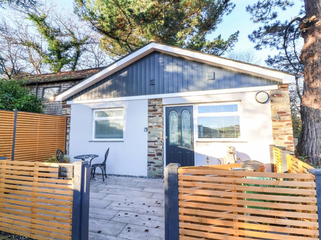 a small white cottage with a wooden fence at Tarka View in Bideford